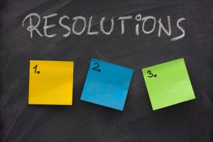 list of resolutions on blackboard with three blank, numbered sticky notes