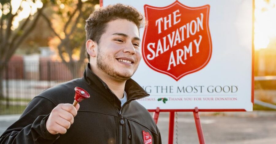man ringing red bell outside of Salvation Army red kettle